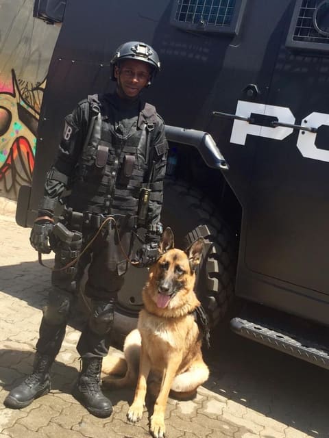 A trained dog beside an actor in police uniform on set